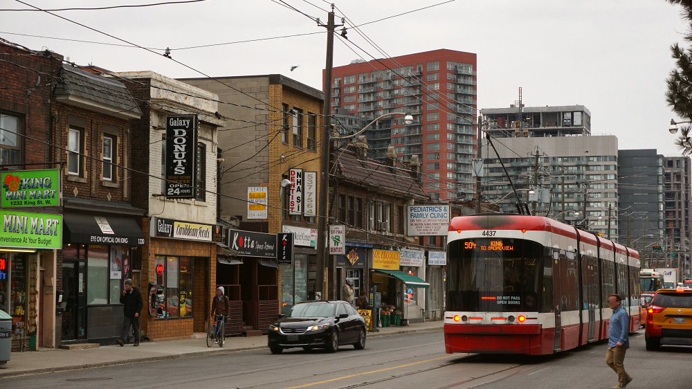 A TTC streetcar travelling through Parkdale on Queen Street West in Toronto